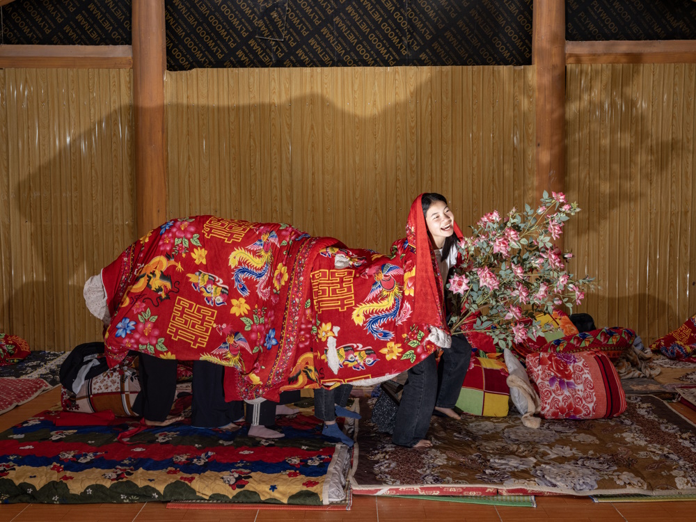 A group of students plays with their blankets creating a human dragon in the dorms of their boarding school in Vietnam (staged images)